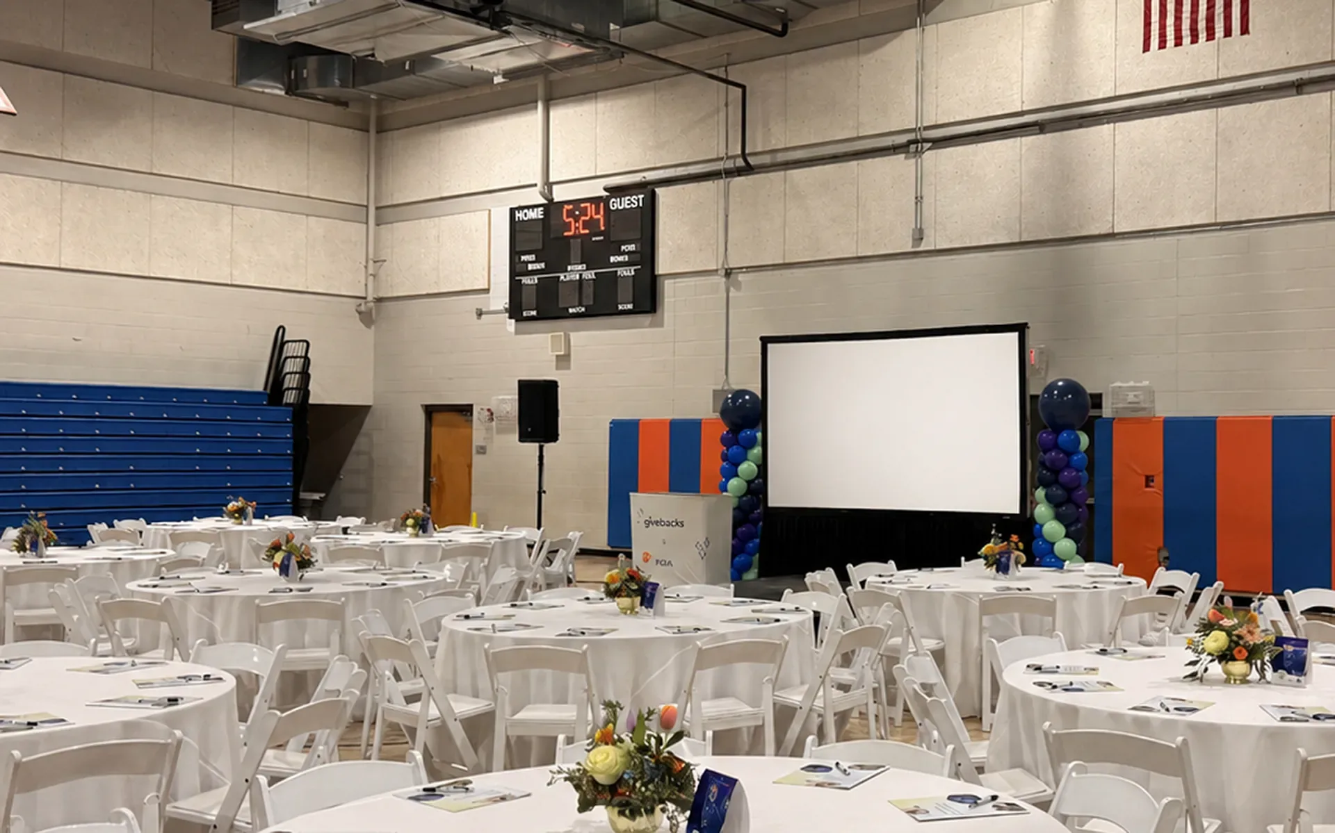 Projection screen and PA speaker setup for a banquet event in a Nashville gymnasium