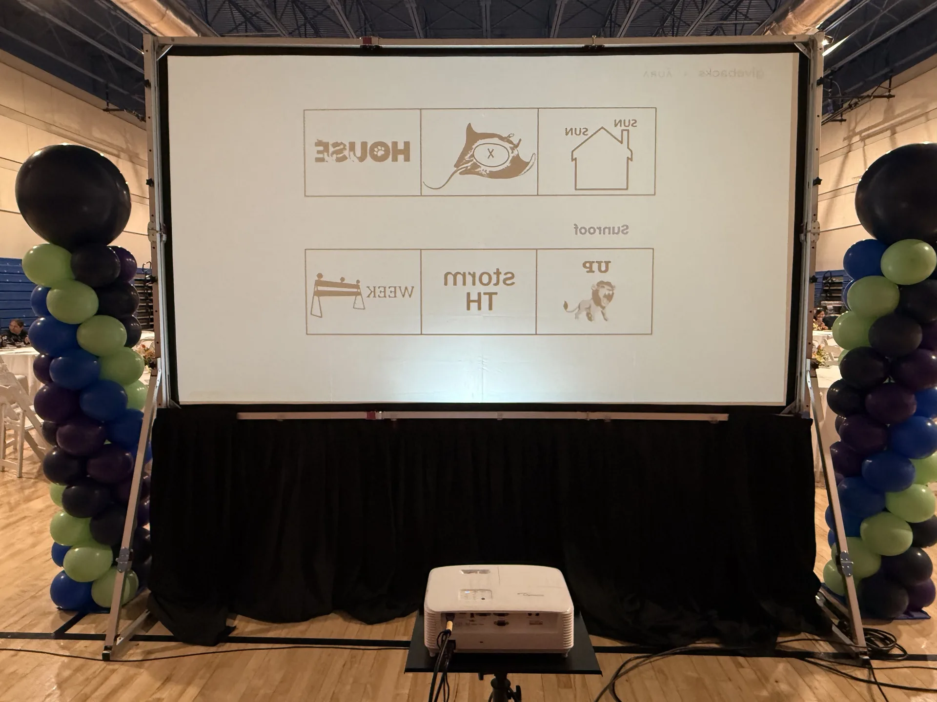 Back view of a rear-projection screen with a mirrored image and balloon columns