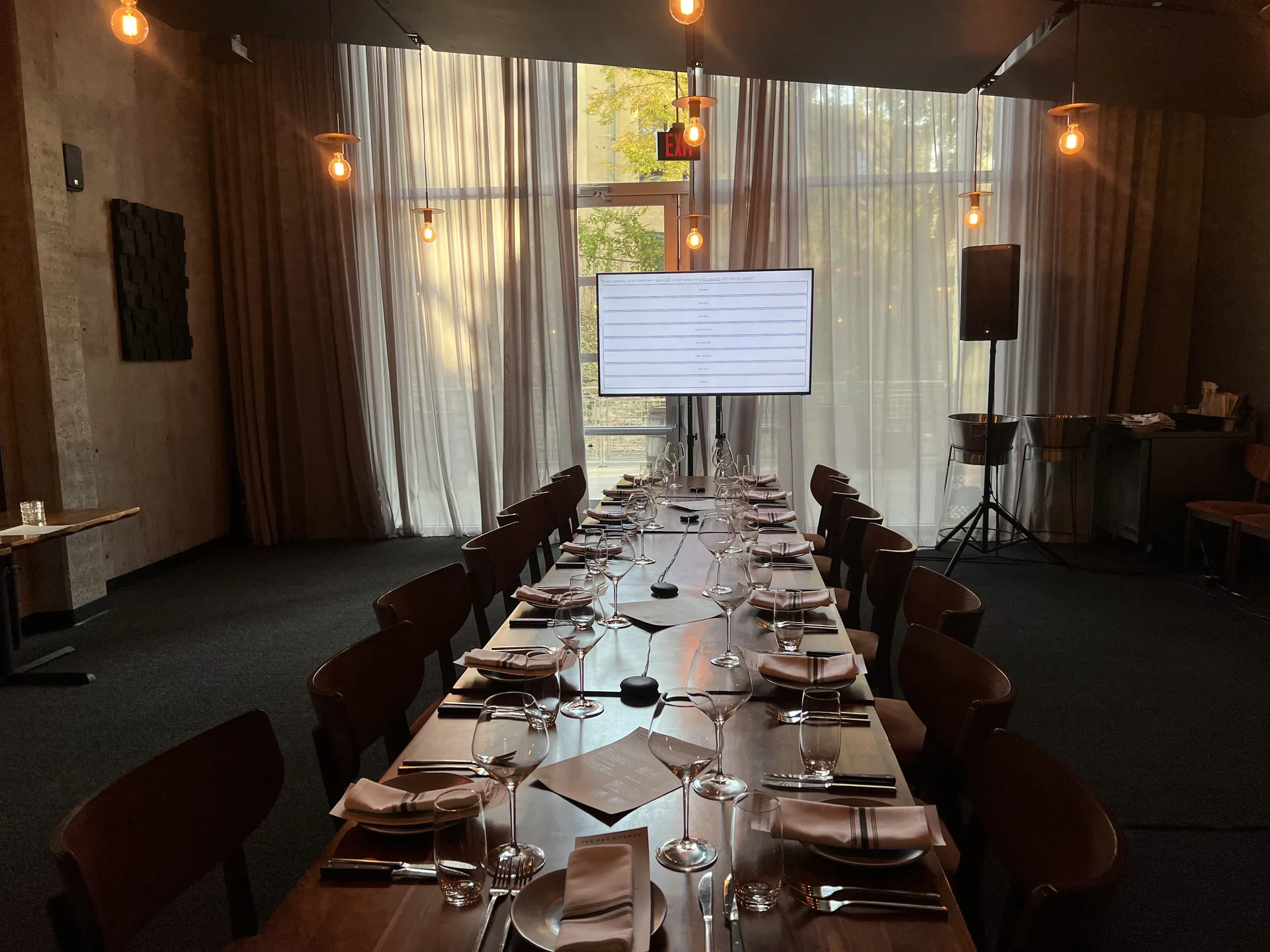 Restaurant dining setup with TV presentation display and PA speaker for a private event
