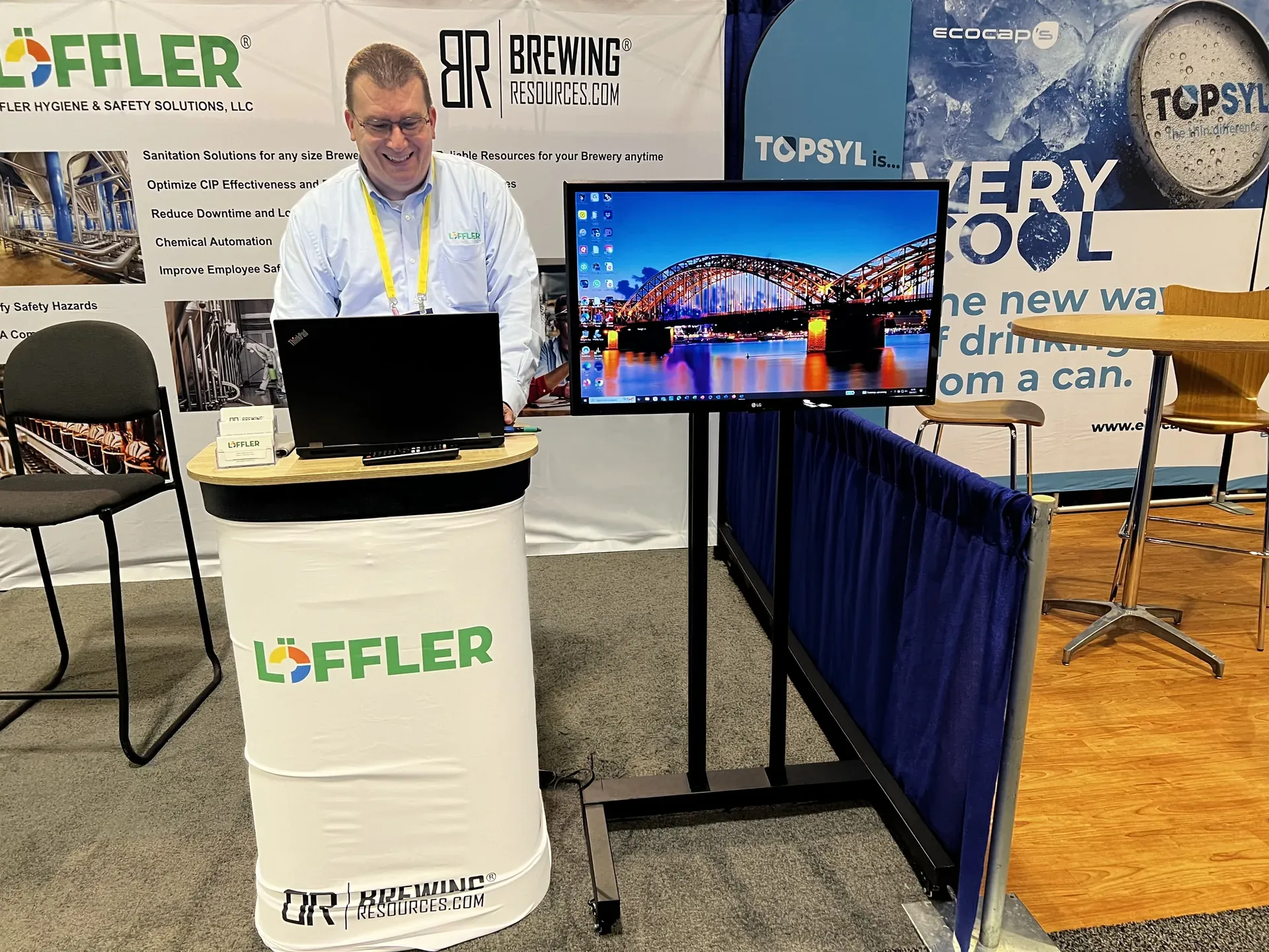 Sanitation solutions trade show booth with a TV display and a representative working