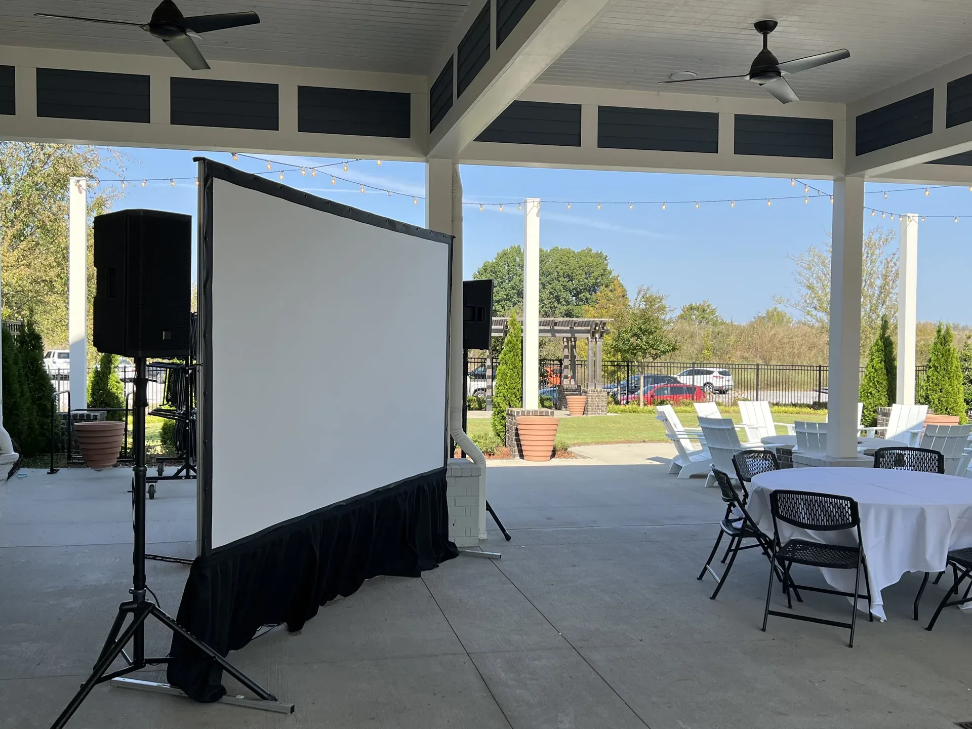 Side view of an outdoor projection screen and PA speaker setup by Channel AV