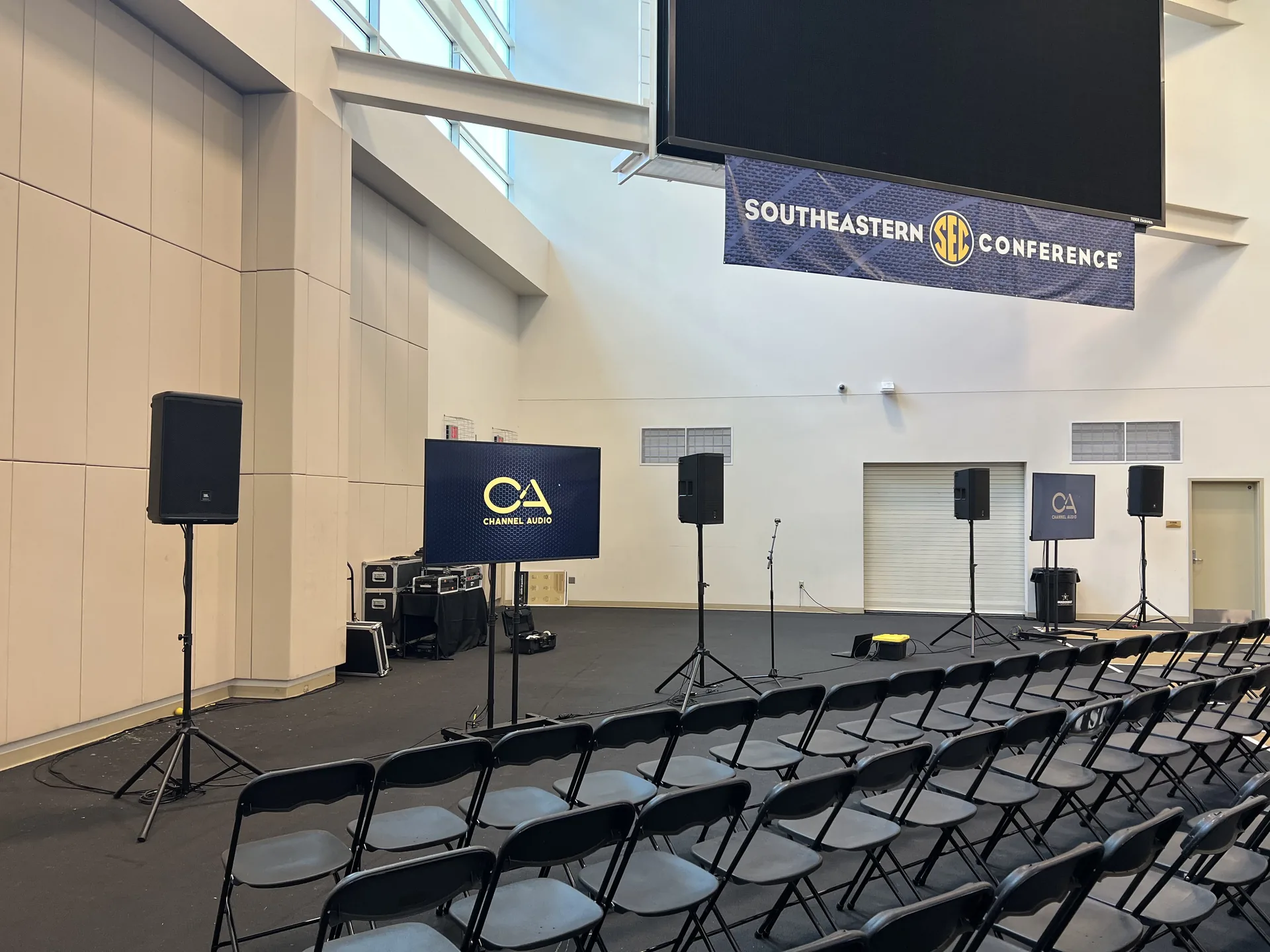 Southeastern Conference setup with TV displays, PA speakers, microphones and Channel AV branding