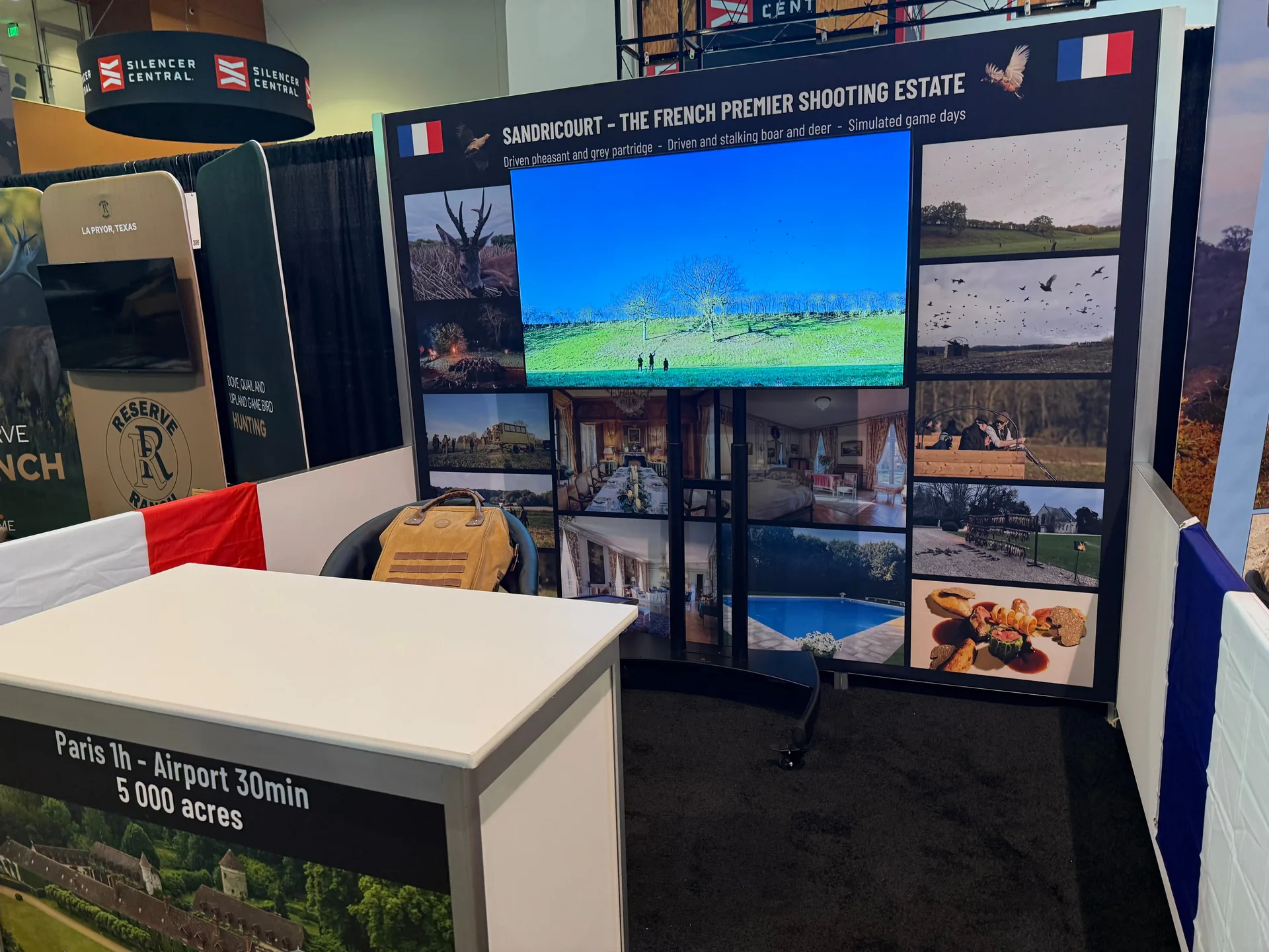 Trade show booth with TV display showing multimedia content and branded wall graphics