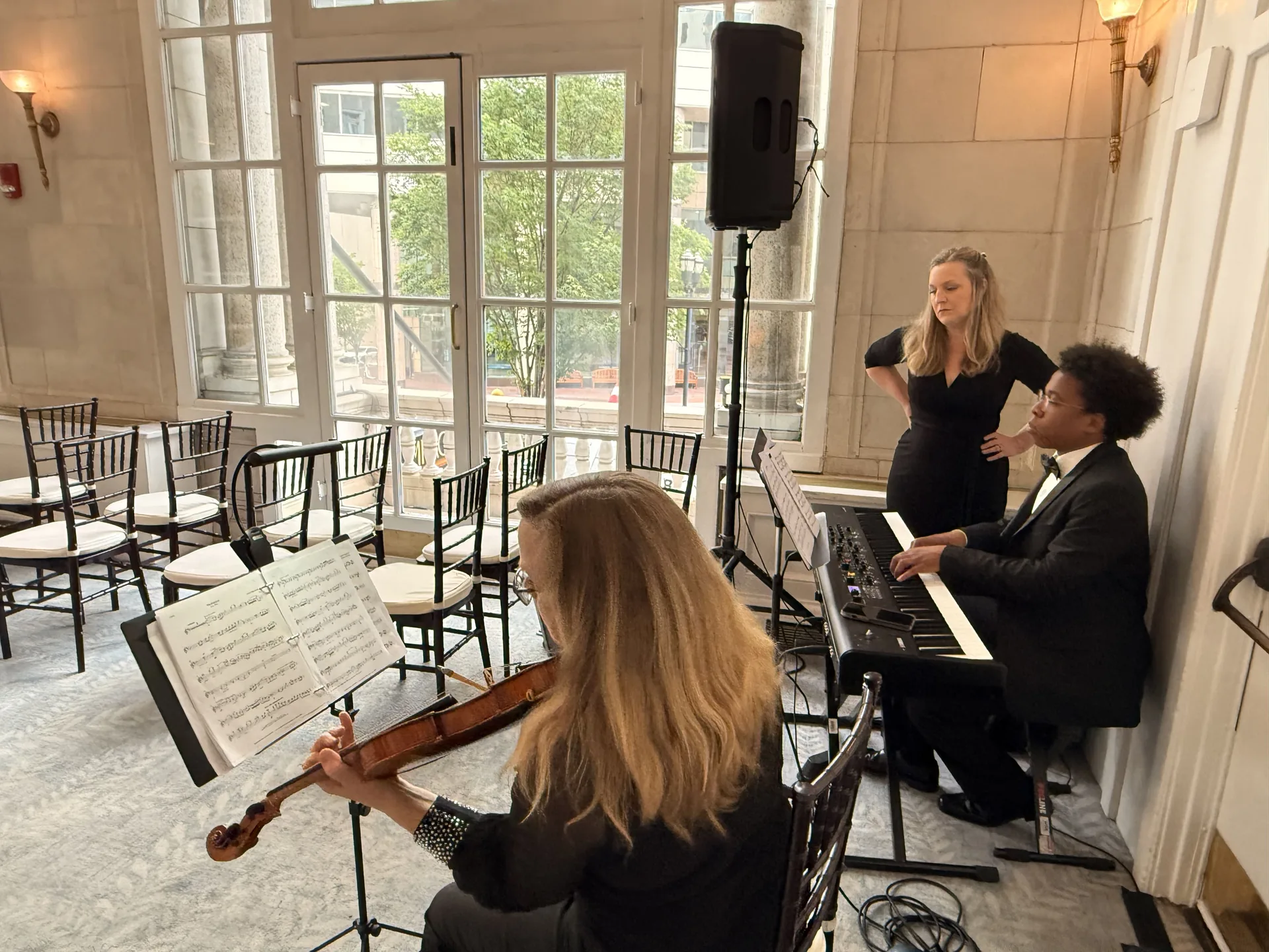 Wedding music setup with a violinist, keyboard player and PA speaker at an elegant venue
