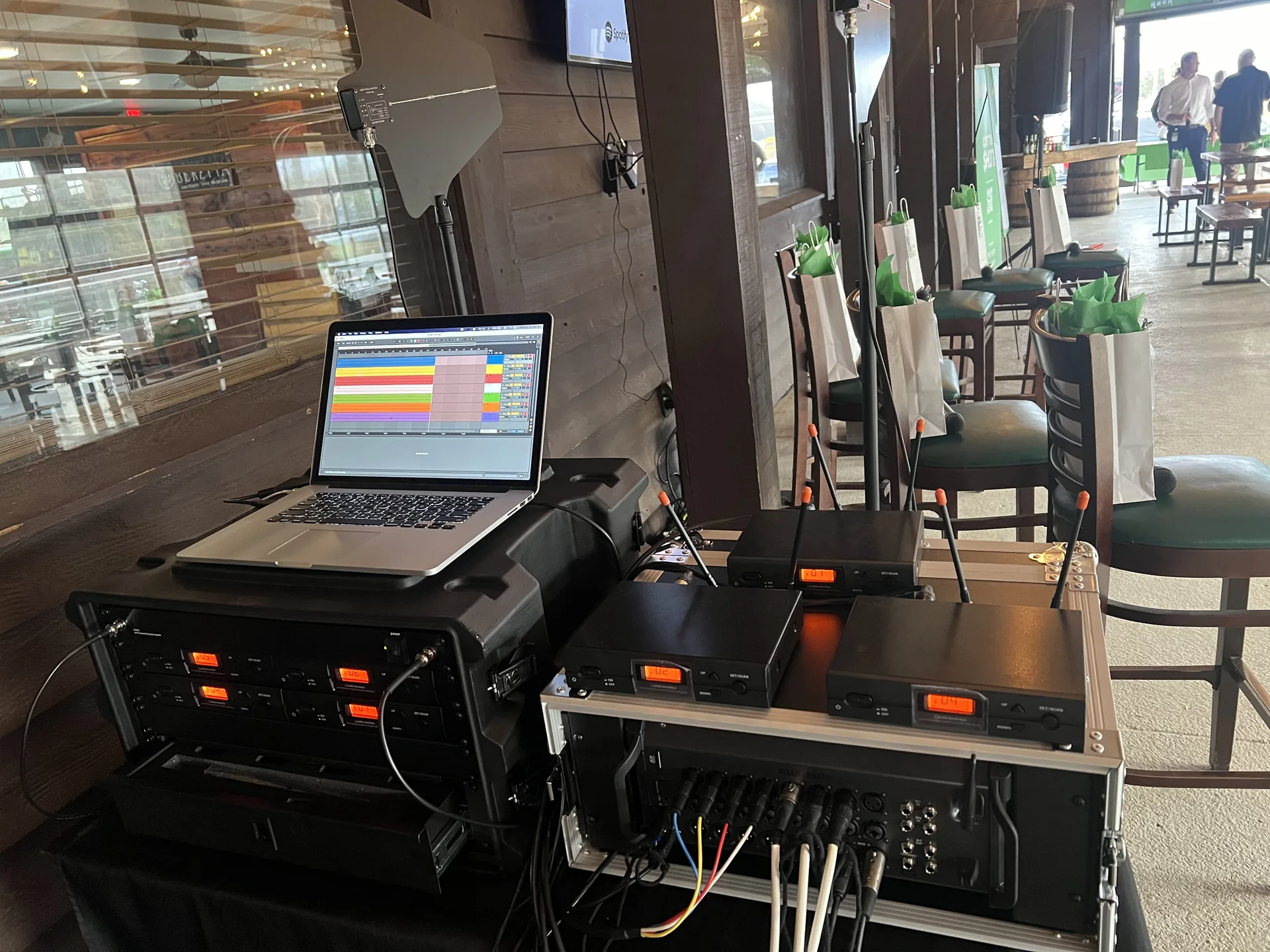 Wireless microphone receivers, audio mixer and laptop set up at a modern event venue